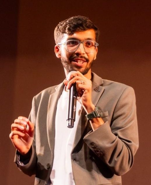 Prakshal speaking on stage with a microphone